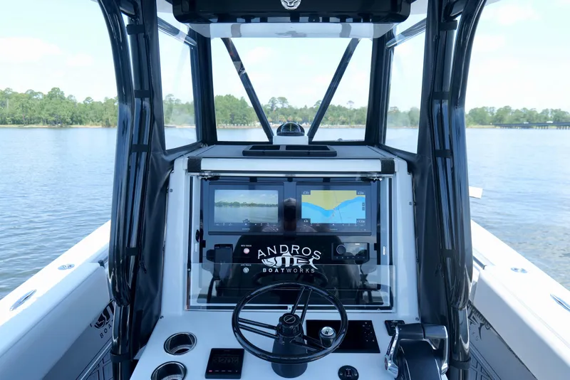 Slide: The Image of 2023 Andros 32 Offshore boat cockpit with navigation screens on a calm lake. - 12
