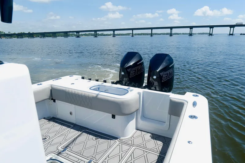 Slide: The Image of 2023 Andros 32 Offshore boat with twin engines on calm water near a bridge. - 20