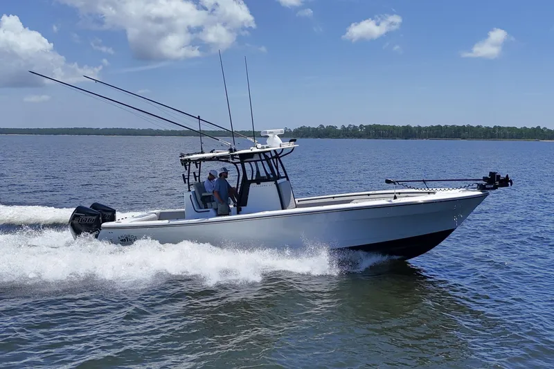 Slide: The Image of 2023 Andros 32 Offshore boat cruising on open water under a clear blue sky. - 5