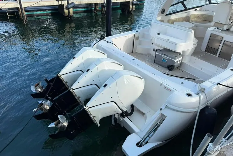 Slide: The Image of 2021 Intrepid 477 Evolution boat with triple outboard engines docked at marina. - 19