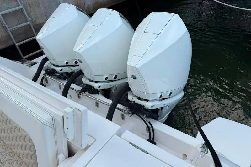 Slide: The Image of Triple outboard motors on a 2021 Intrepid 477 Evolution boat, docked by the water. - 21