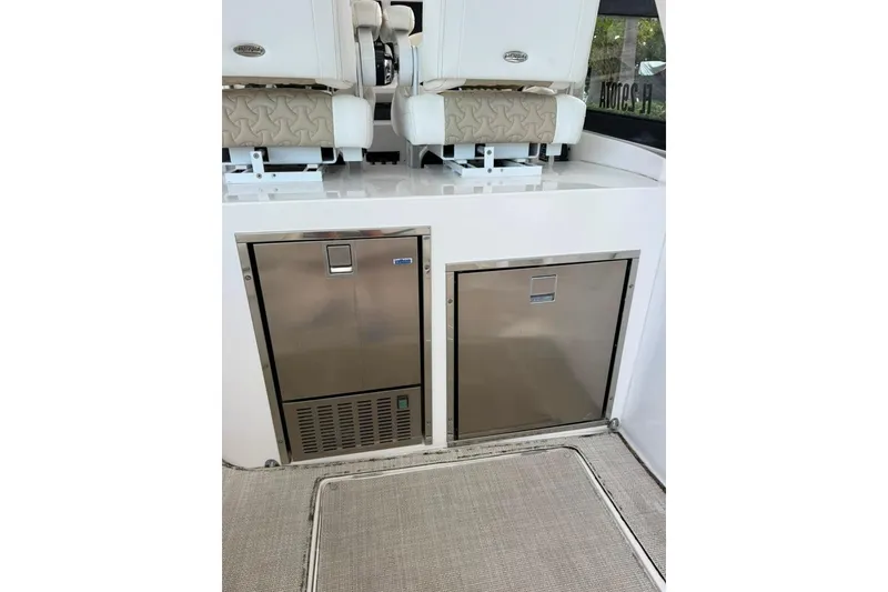 Slide: The Image of 2021 Intrepid 477 Evolution boat interior with stainless steel appliances and cushioned seating. - 5