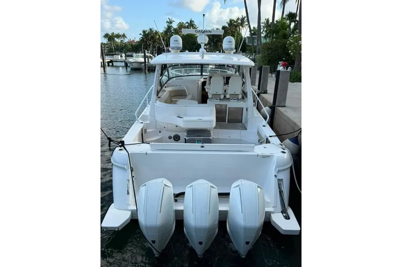 Slide: The Image of 2021 Intrepid 477 Evolution boat docked with triple outboard engines. - 20