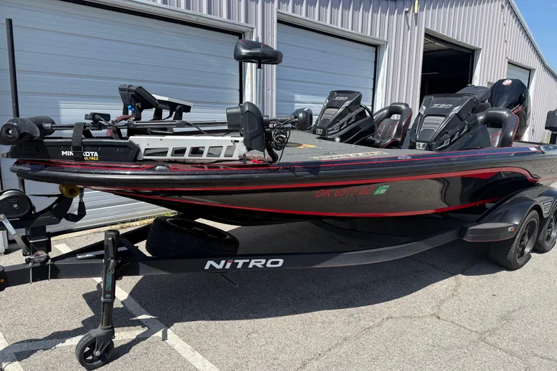 Slide: The Image of 2021 Nitro Z20 boat with Minn Kota Ultrex motor, parked outside a garage. - 88