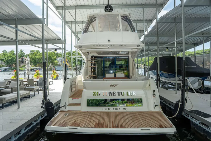 Slide: The Image of 2025 Pacific Prestige 460 Fly yacht docked at Porto Cima, MO, with "No Time to Die" signage. - 18