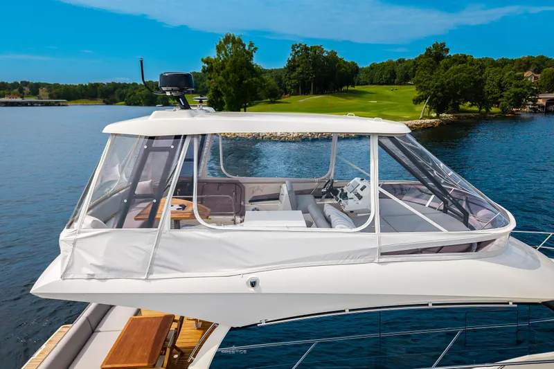 Slide: The Image of Luxury 2025 Pacific Prestige 460 Fly yacht with enclosed flybridge on serene lake. - 12
