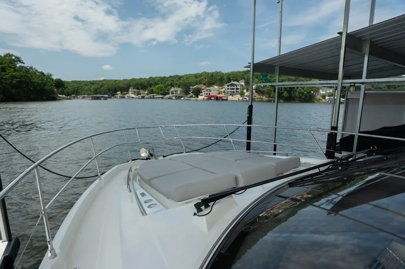 Slide: The Image of 2025 Pacific Prestige 460 Fly yacht docked on a serene lake with scenic views. - 23