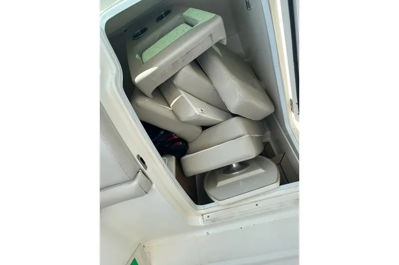 Slide: The Image of 2015 Boston Whaler 270 Vantage interior storage with stacked cushions. - 26