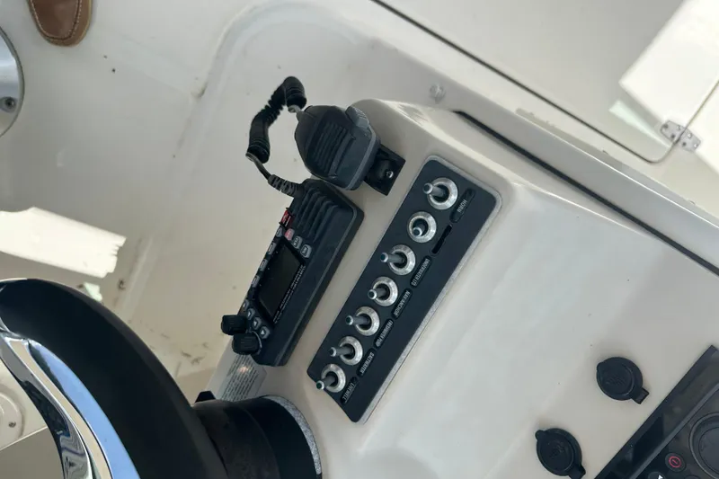 Slide: The Image of Control panel of a 2015 Boston Whaler 270 Vantage boat with radio and switches. - 24