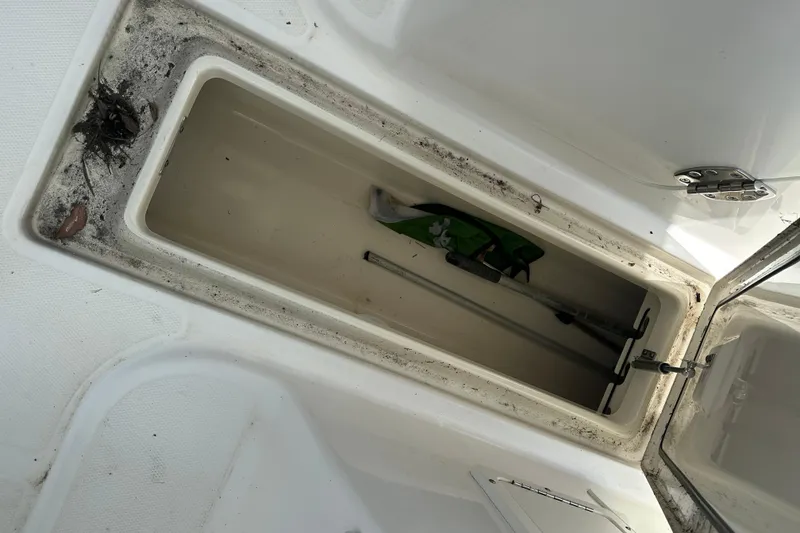 Slide: The Image of Storage compartment of a 2015 Boston Whaler 270 Vantage boat, containing fishing gear. - 20