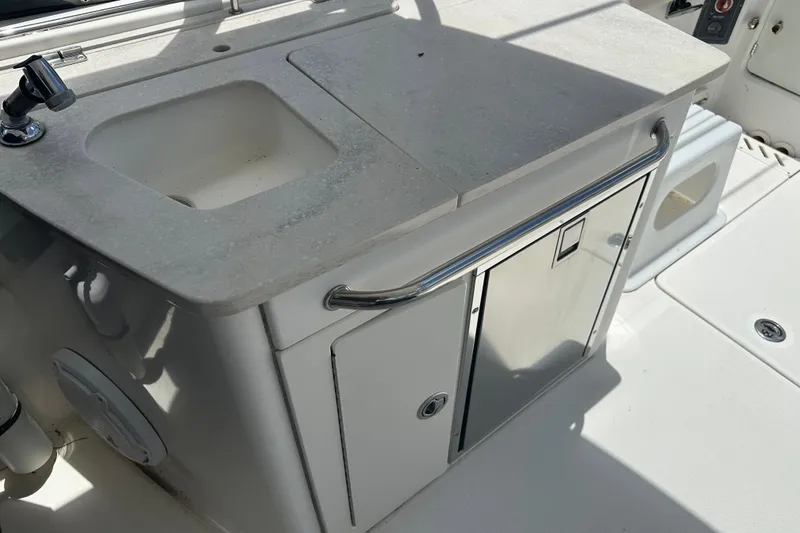 Slide: The Image of 2015 Boston Whaler 270 Vantage boat sink and storage area in sunlight. - 31