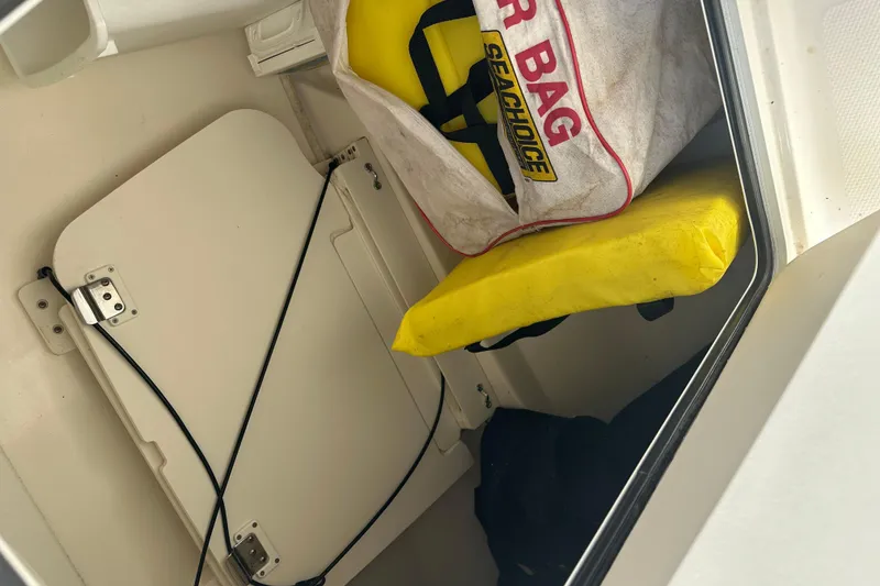 Slide: The Image of Storage compartment in a 2015 Boston Whaler 270 Vantage with safety gear and life jacket. - 27