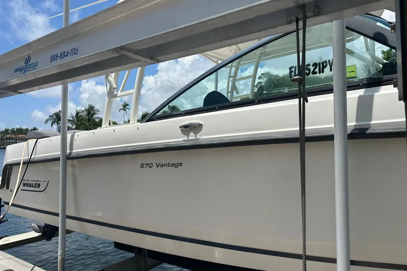 Slide: The Image of 2015 Boston Whaler 270 Vantage boat docked, showcasing sleek design and branding. - 8