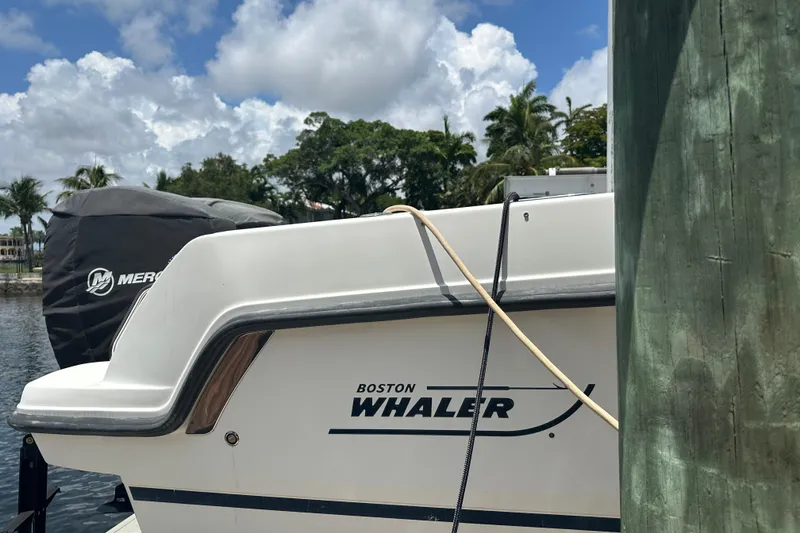 Slide: The Image of 2015 Boston Whaler 270 Vantage boat docked, featuring Mercury engine cover. - 12