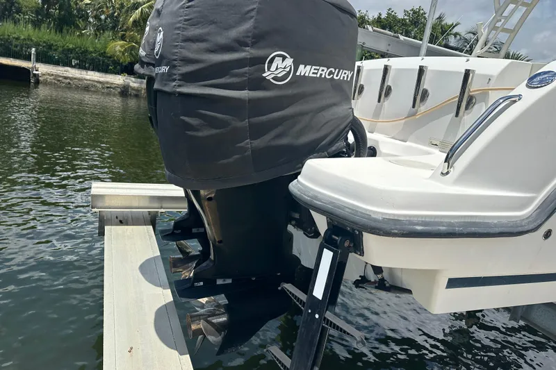 Slide: The Image of 2015 Boston Whaler 270 Vantage with Mercury outboard motor, docked by the water. - 13