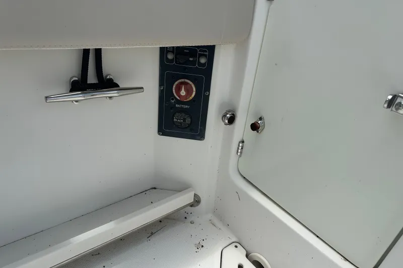Slide: The Image of 2015 Boston Whaler 270 Vantage boat interior showing battery switch and storage compartment. - 33