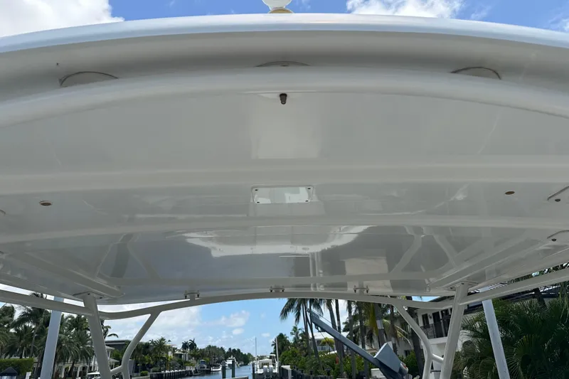Slide: The Image of 2015 Boston Whaler 270 Vantage boat canopy with clear sky and palm trees in background. - 35