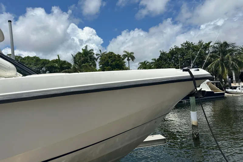 Slide: The Image of 2015 Boston Whaler 270 Vantage boat docked by tropical waters under a partly cloudy sky. - 6