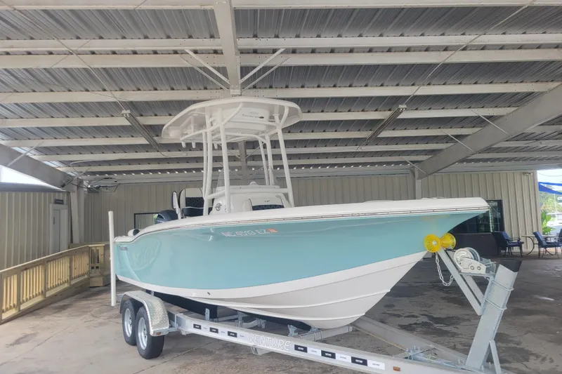 Slide: The Image of 2023 Tidewater 210 LXF boat on trailer under metal roof in storage facility. - 0