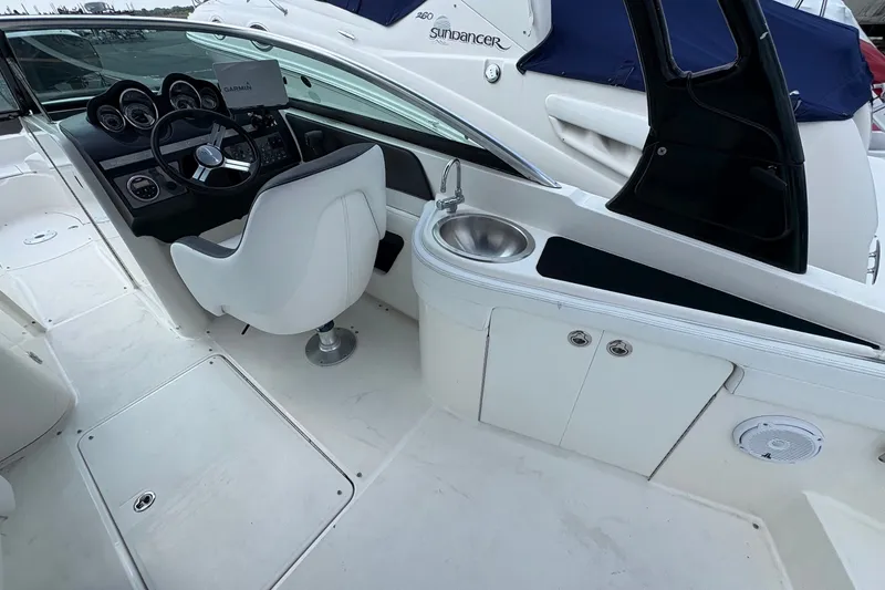 Slide: The Image of 2014 Sea Ray 260 Sundeck cockpit with steering wheel, sink, and seating. - 10