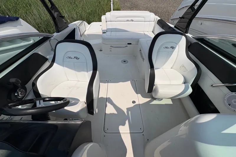 Slide: The Image of 2014 Sea Ray 260 Sundeck interior with white seating and steering wheel. - 11