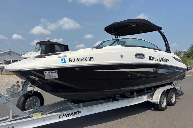 Slide: The Image of 2014 Sea Ray 260 Sundeck boat on trailer, for sale, under clear blue sky. - 2