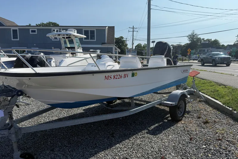 Slide: The Image of 2008 Boston Whaler 150 Sport boat on trailer, parked outdoors on gravel. - 5