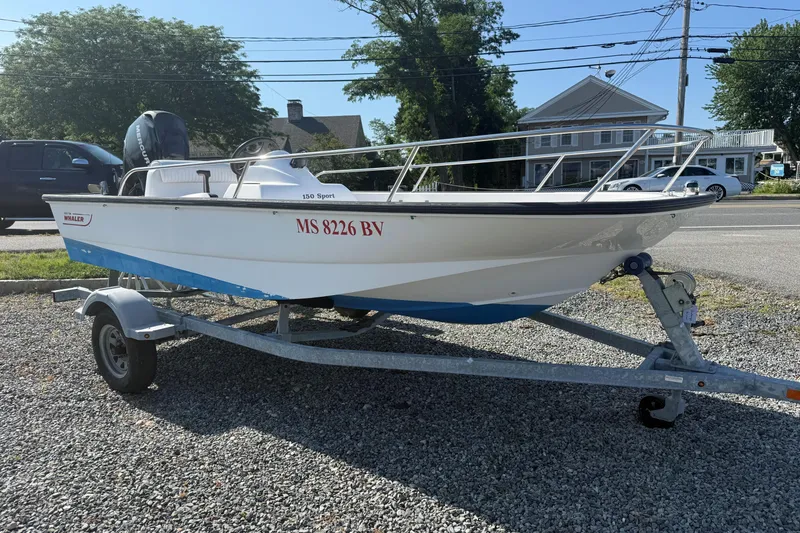 Slide: The Image of 2008 Boston Whaler 150 Sport boat on trailer, parked on gravel lot. - 3