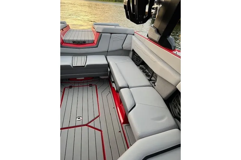 Slide: The Image of 2025 Nautique Super Air Nautique G23 interior with sleek gray seating and red accents. - 11