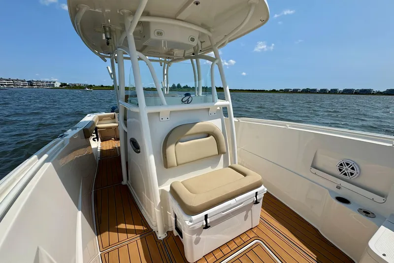 Slide: The Image of 2017 Sailfish 290 CC boat interior with seating, on a sunny day at sea. - 29