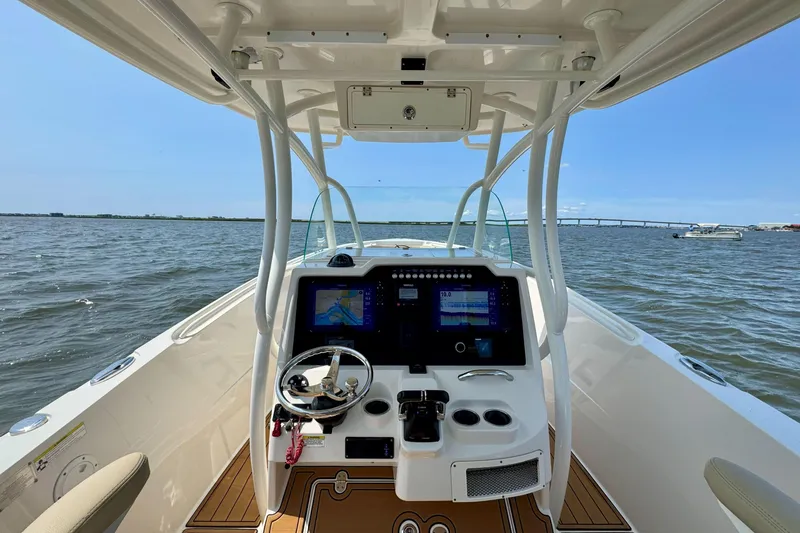 Slide: The Image of 2017 Sailfish 290 CC boat dashboard with navigation screens on open water. - 10