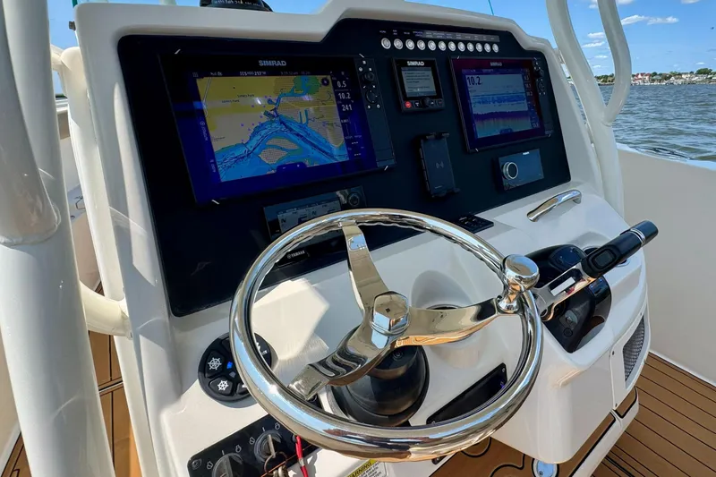 Slide: The Image of 2017 Sailfish 290 CC boat dashboard with navigation screens and steering wheel. - 12