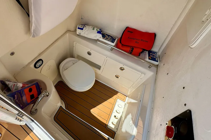 Slide: The Image of 2017 Sailfish 290 CC boat bathroom with emergency marine kit and wooden flooring. - 33