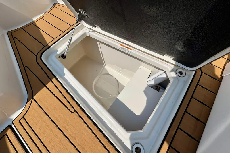 Slide: The Image of Open storage compartment on 2017 Sailfish 290 CC boat with teak flooring. - 32
