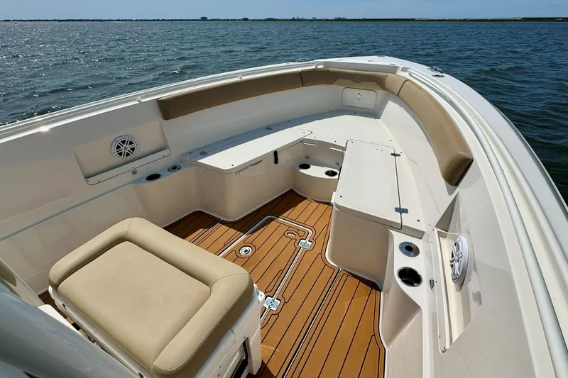 Slide: The Image of 2017 Sailfish 290 CC boat interior with cushioned seating and teak flooring on open water. - 30