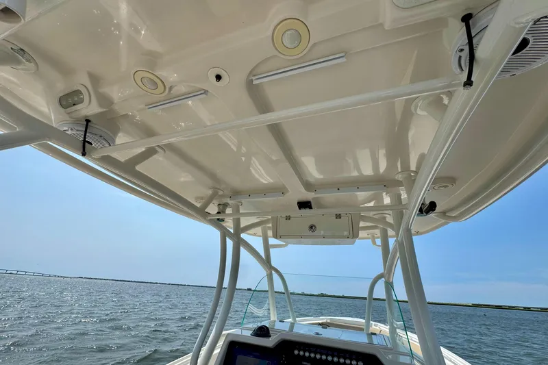Slide: The Image of 2017 Sailfish 290 CC boat interior, featuring a sleek overhead console and ocean view. - 15