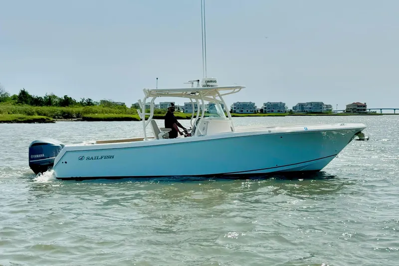 Slide: The Image of 2017 Sailfish 290 CC boat cruising on water with Yamaha engine, coastal background. - 2