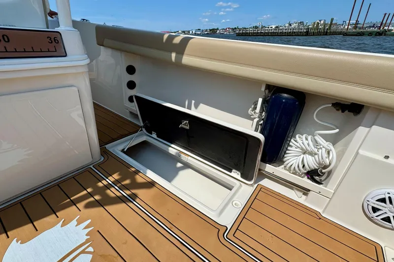 Slide: The Image of 2017 Sailfish 290 CC boat interior with open storage compartment and coiled rope. - 25