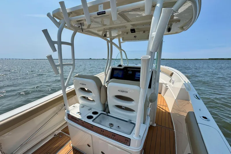 Slide: The Image of 2017 Sailfish 290 CC boat on water, featuring helm and seating area. - 20