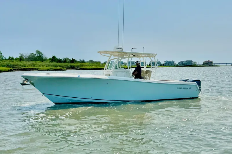 Slide: The Image of 2017 Sailfish 290 CC boat cruising on calm waters near a coastal area. - 3