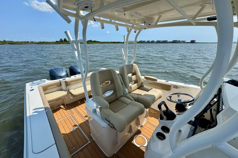 Slide: The Image of 2017 Sailfish 290 CC boat interior with dual seats, steering wheel, and ocean view. - 17