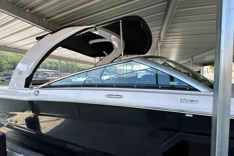 Slide: The Image of 2017 Four Winns H290 boat docked under a covered marina. - 48