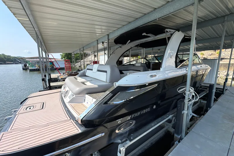 Slide: The Image of 2017 Four Winns H290 boat docked under a covered marina, showcasing sleek design and spacious seating. - 4