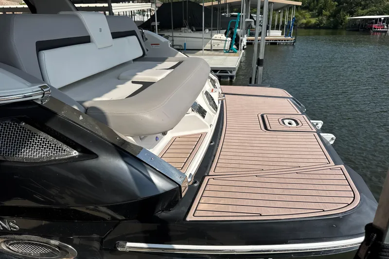 Slide: The Image of 2017 Four Winns H290 boat with spacious rear deck and comfortable seating at a dock. - 5