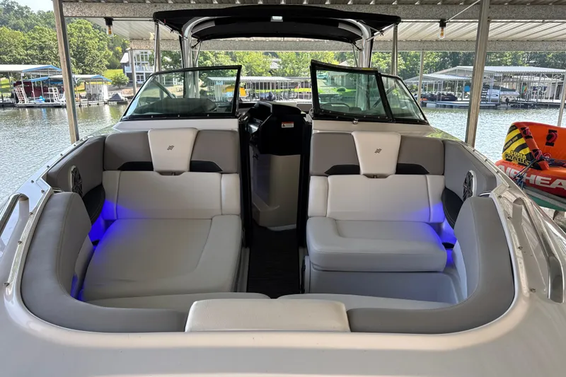 Slide: The Image of 2017 Four Winns H290 boat interior with white seating and blue accent lighting. - 18