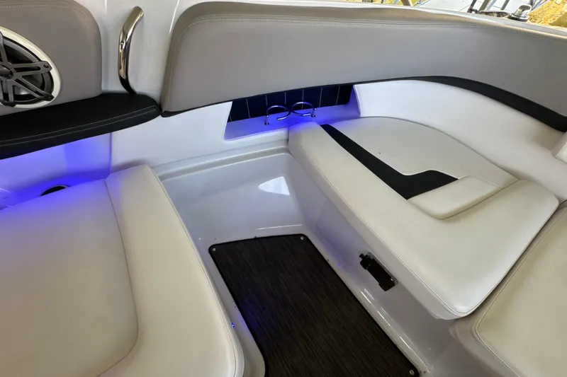 Slide: The Image of 2017 Four Winns H290 boat interior with cushioned seating and ambient blue lighting. - 31