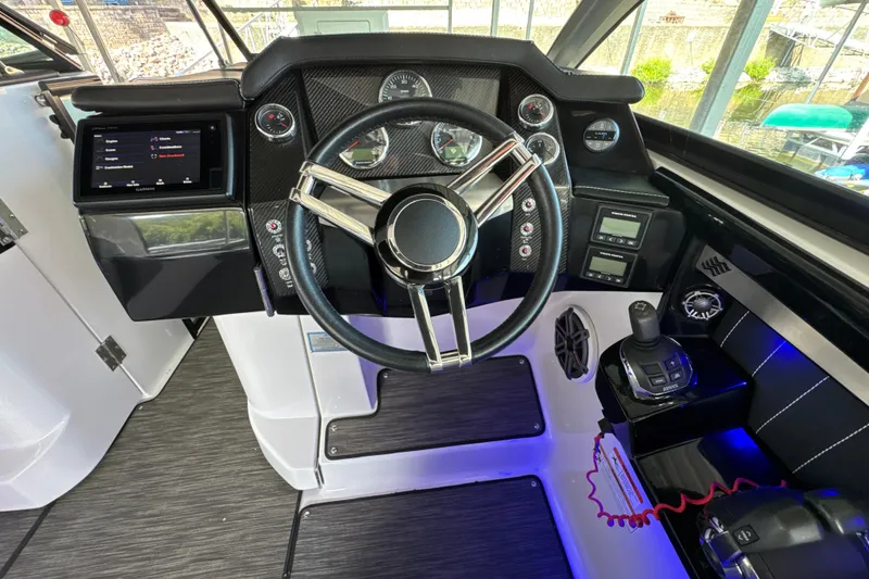 Slide: The Image of 2017 Four Winns H290 boat dashboard with steering wheel, gauges, and navigation controls. - 8