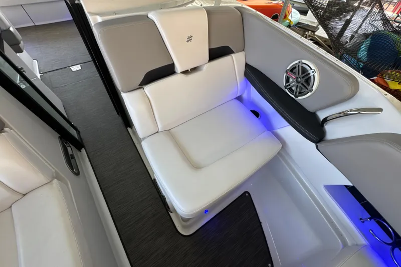 Slide: The Image of 2017 Four Winns H290 boat interior with white seating and speaker, featuring ambient blue lighting. - 24