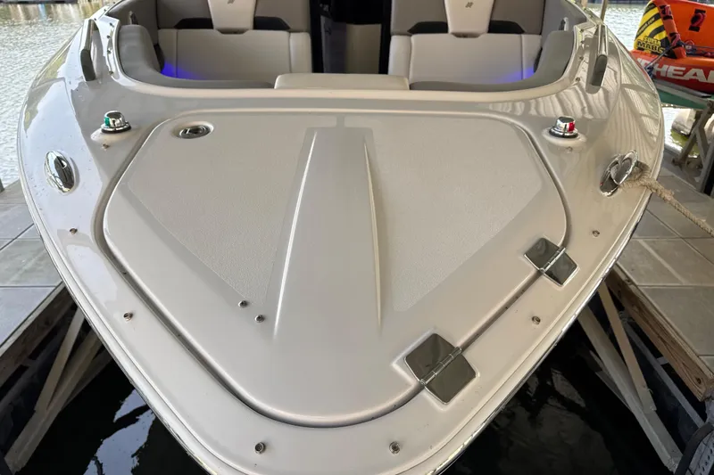 Slide: The Image of 2017 Four Winns H290 boat bow, docked with visible seating and water reflection. - 52