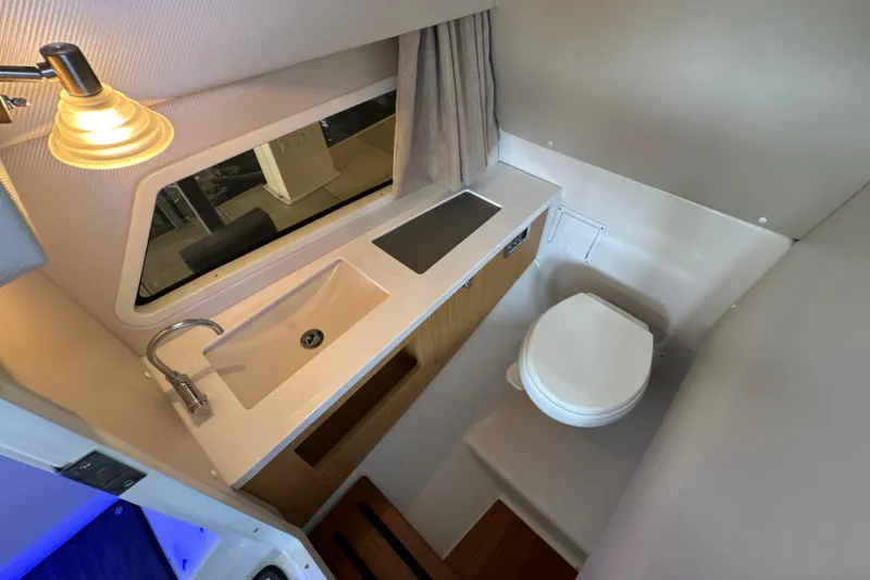 Slide: The Image of 2017 Four Winns H290 boat bathroom with sink, toilet, and window. - 28